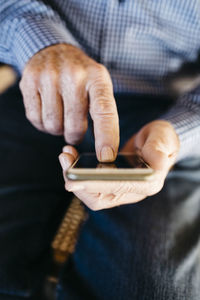Hands of senior man using smartphone