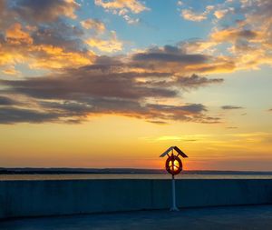 Yellow umbrella on sea shore against sky during sunset