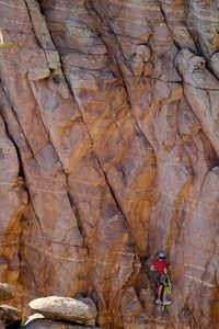 Rear view of man rock climbing