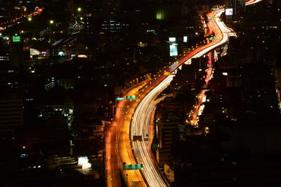 High angle view of illuminated street amidst buildings at night