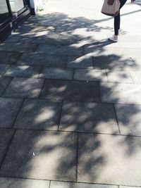 Low section of woman standing on sidewalk