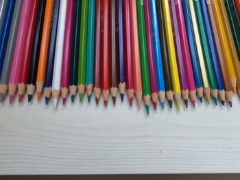 High angle view of multi colored pencils in row