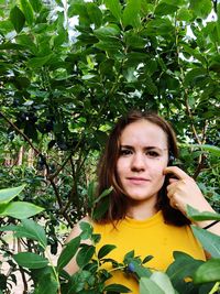 Portrait of woman standing against plants