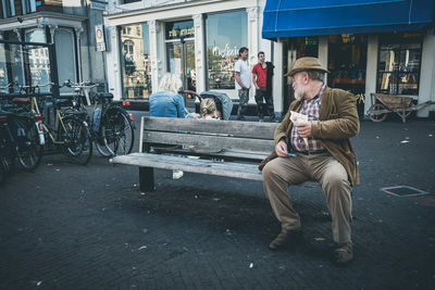 Men sitting on street in city