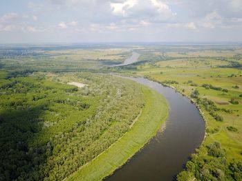High angle view of river amidst field against sky