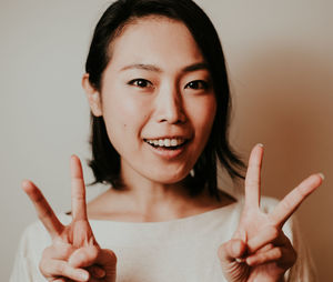 Portrait of smiling woman standing against wall