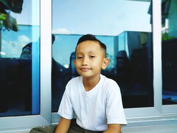 Portrait of cute boy looking through window