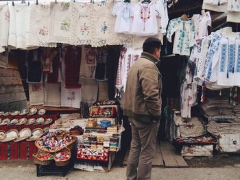 Man standing against market stall