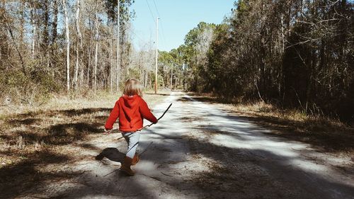 Rear view of woman walking on road