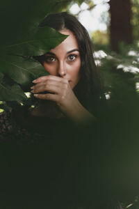 Portrait of young woman against tree