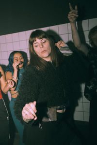 Transgender woman dancing against friends at nightclub