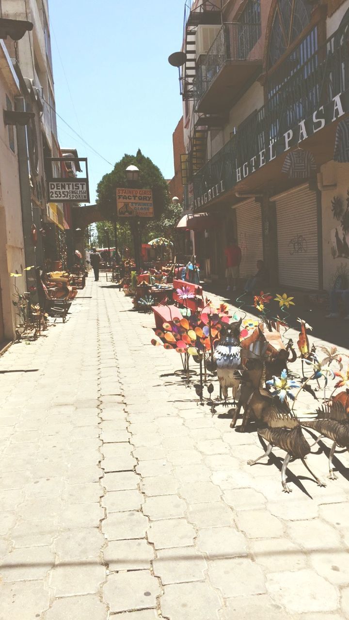 building exterior, architecture, built structure, street, city, market, city life, cobblestone, incidental people, market stall, day, retail, outdoors, residential building, residential structure, large group of people, sidewalk, person, building