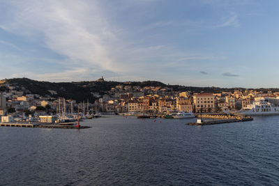 Sailboats in sea against buildings in city