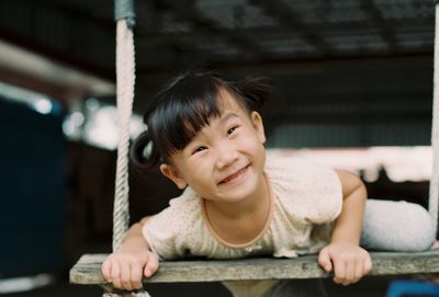 Portrait of smiling girl on swing