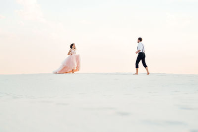 Rear view of couple standing on beach