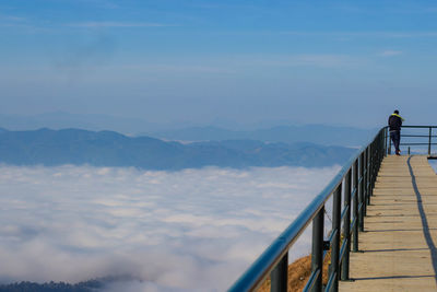 Rear view of man looking at mountain against sky