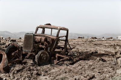 Abandoned truck on field against clear sky