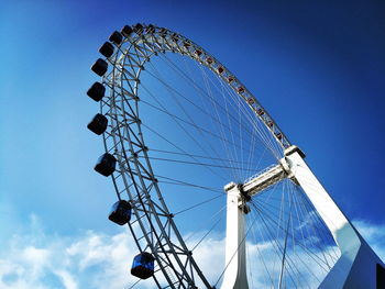 Low angle view of ferris wheel against blue sky