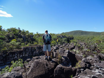 Full length of man standing on rock against sky