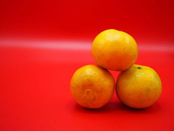 Close-up of oranges against red background