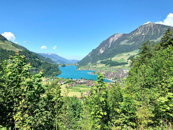 Scenic view of sea and mountains against blue sky