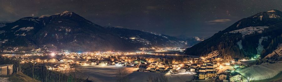 Panoramic view of illuminated city against sky at night during winter