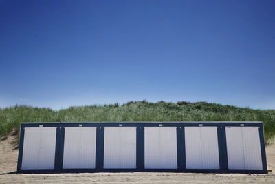 Trees on field against clear blue sky