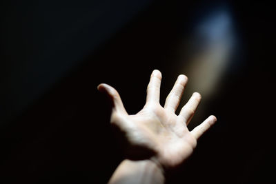 Close-up of hand gesturing in darkroom