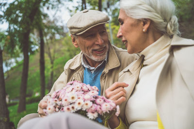 Laughing senior couple sitting at park