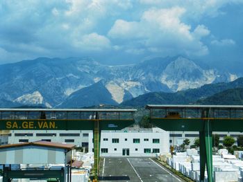 Road by mountains against sky