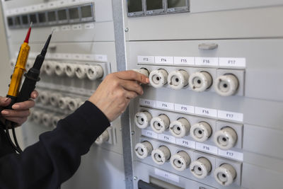 Hand of female technician operating electrical fuse box