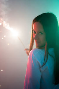 Portrait of woman holding illuminated sparkler