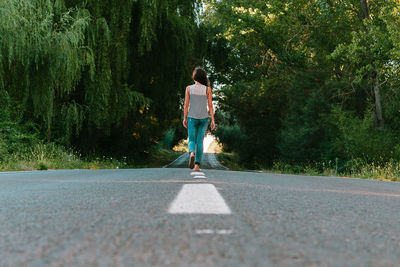 Rear view of woman walking on road