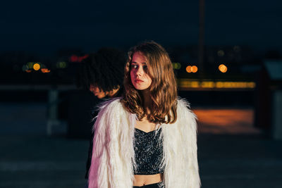 Portrait of beautiful woman standing at night