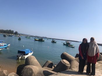 Rear view of people looking at sea against clear sky