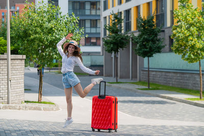 Woman holding umbrella on footpath