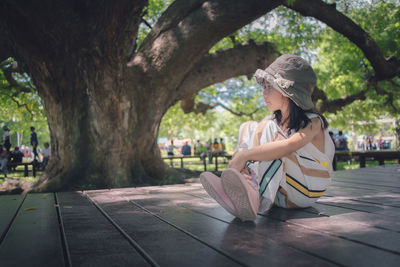 Cute little girl under the big tree in public park