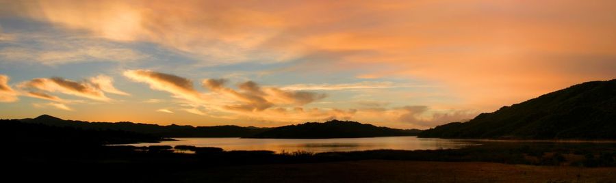 Panoramic view of sea and mountains against sky