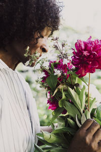 Mature woman smelling fresh flowers in garden