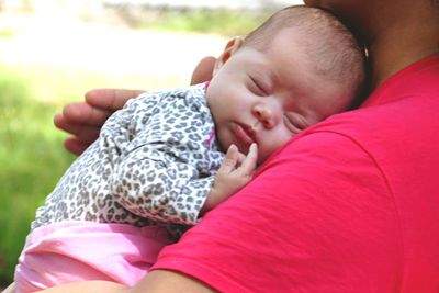 Close-up of baby sleeping on shoulder of father