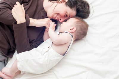 Mother and baby lying on bed