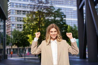 Portrait of young woman standing in city