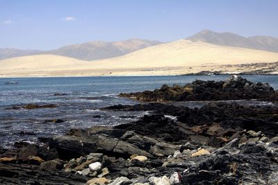 Scenic view of sea and mountains against sky