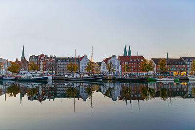 Reflection of buildings in river against sky