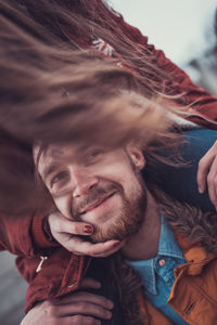 Portrait of a smiling young man holding camera