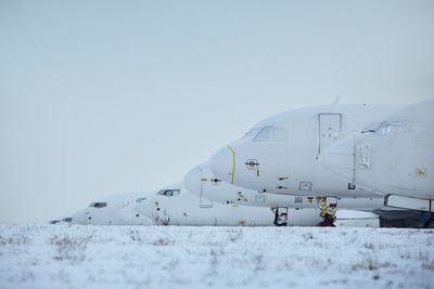 Airplane on runway against clear sky during winter