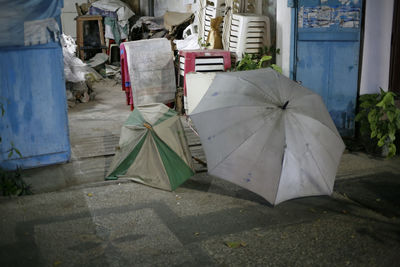 Umbrellas on footpath by street in city