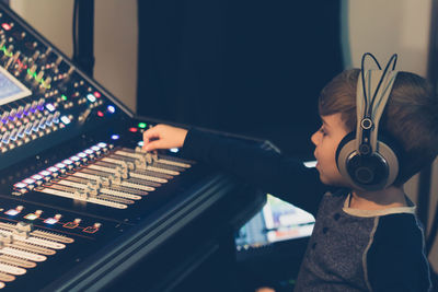 Cute boy mixing music in recording studio