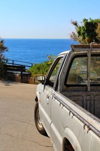 Car on beach against clear sky