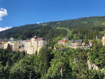 Scenic view of trees and houses against sky